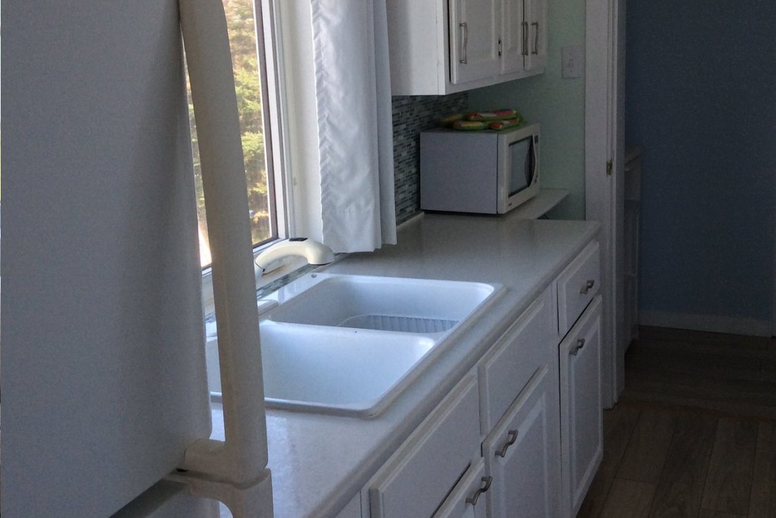 Kitchen counter, window, microwave and sink in self-contained suite